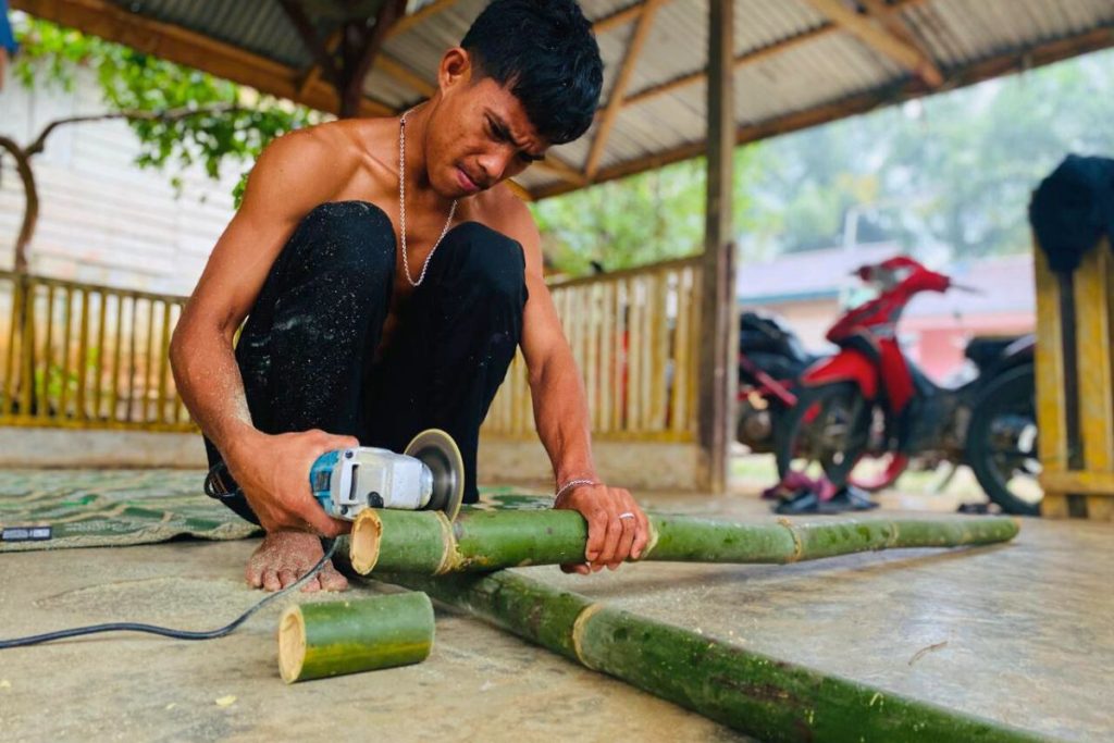 Baim sedang memotong bambu yang akan diproduksi menjadi cawan. Foto: Annisa Majesty Kasturi / Pundi Sumatra